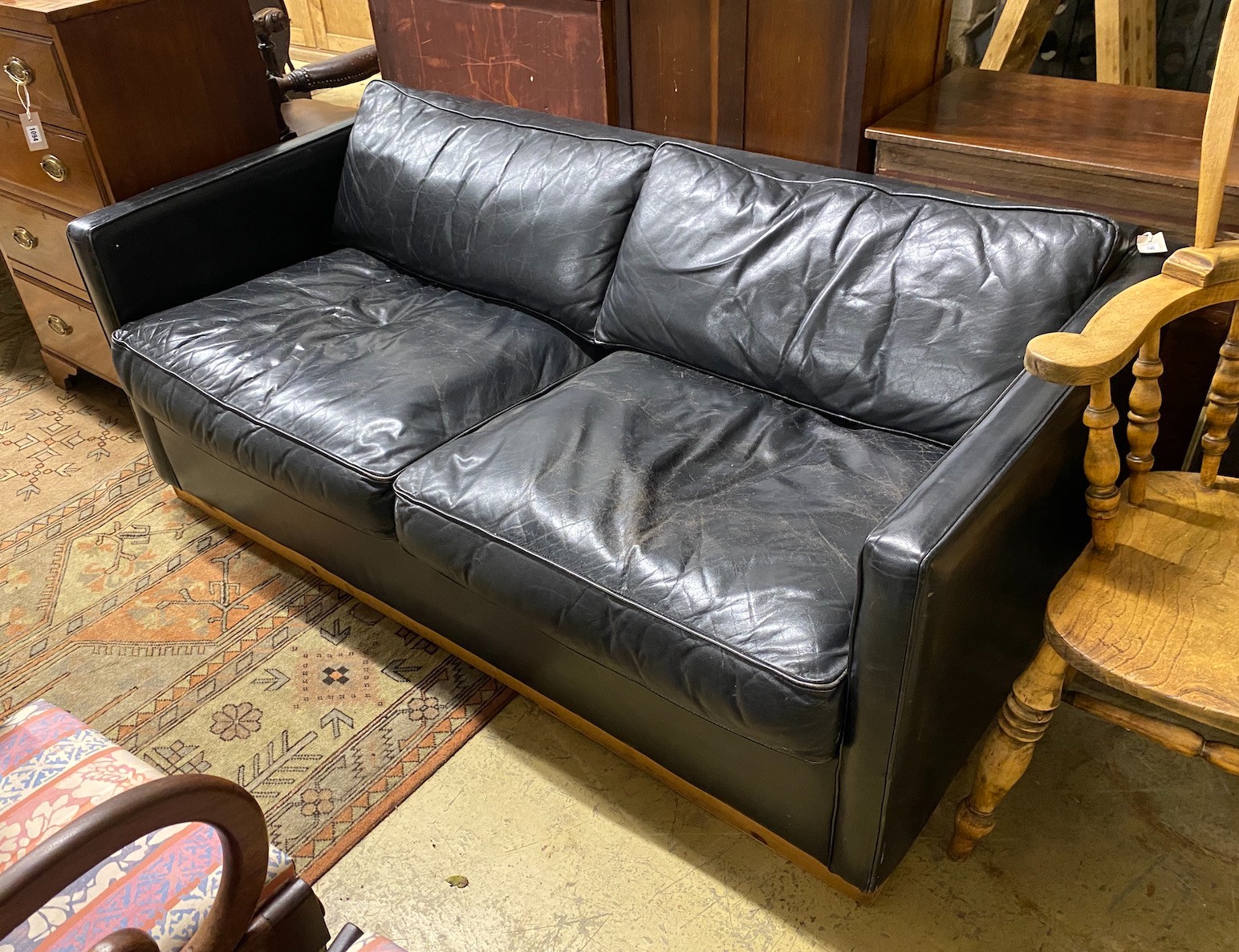 A black leather upholstered two seater sofa bed, length 172cm